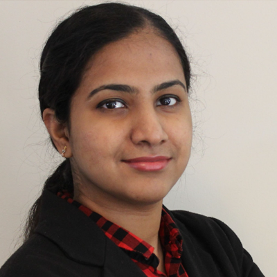 Jahnavi Jonnalagadda, IST PhD student at Mason, wears a red, plaid blouse and dark blazer in her profile.